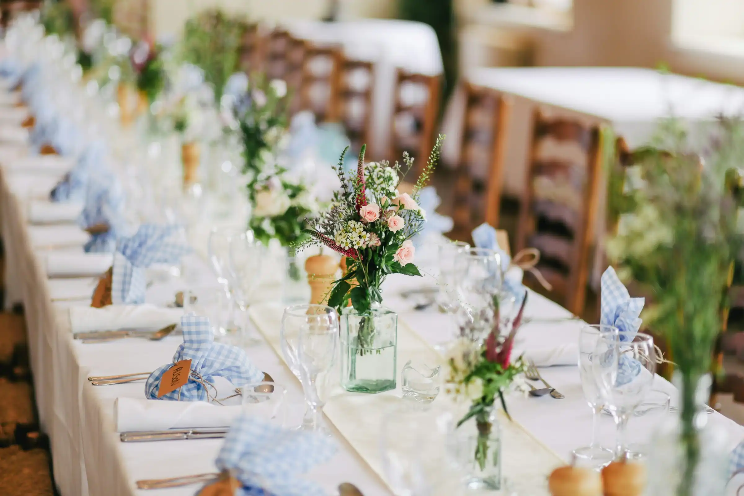 A long table set with linen, glasses and flowers