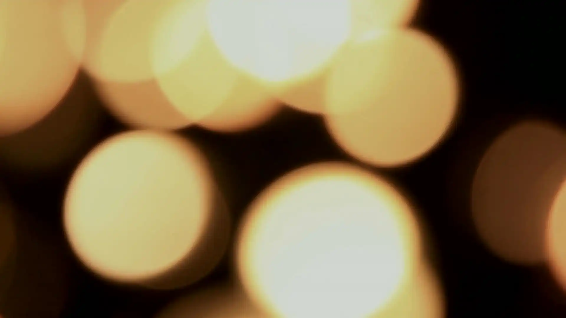 Warm light out of focus behind a glass, then a dark cellar and a pen on paper